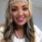 Woman with long, wavy hair smiling into the camera.