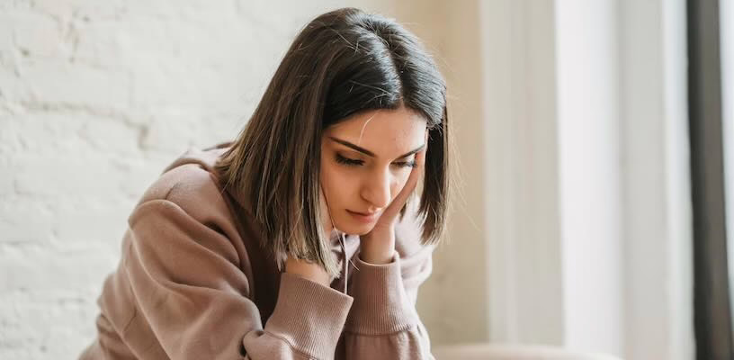 Pregnant woman with headache rubbing her temples.