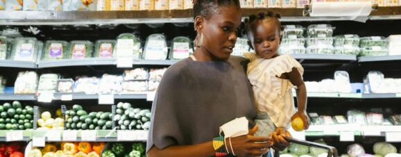 Mother holding her baby despite suffering from mommy wrist.