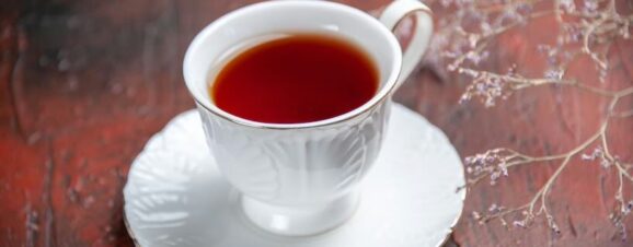 A full cup of red raspberry leaf tea sitting on a saucer.