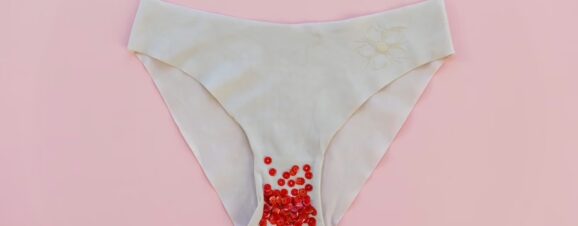 Women's underwear with red glitter on it, which represents mild spotting during pregnancy.