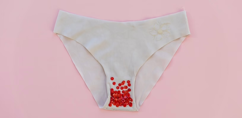 Women's underwear with red glitter on it, which represents mild spotting during pregnancy.