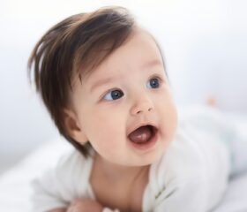 A young baby lying on her stomach, symbolizing the age when babies become less vulnerable to sudden infant death syndrome.