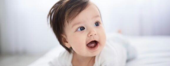 A young baby lying on her stomach, symbolizing the age when babies become less vulnerable to sudden infant death syndrome.