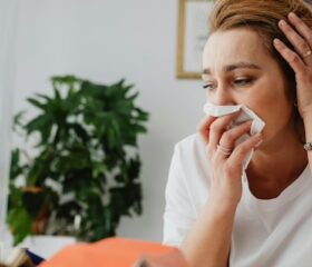 Pregnant woman with a cold contemplating which medicine she should take.