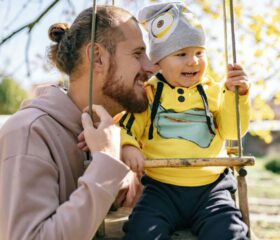 Father taking his baby on a swing.