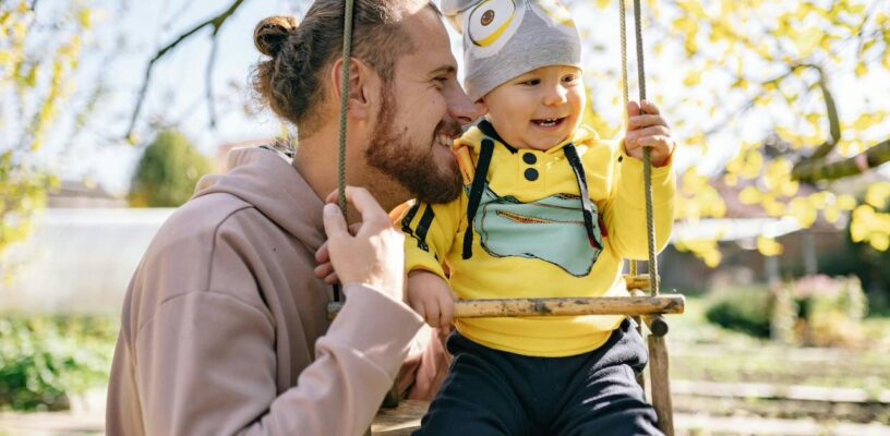 Father taking his baby on a swing.